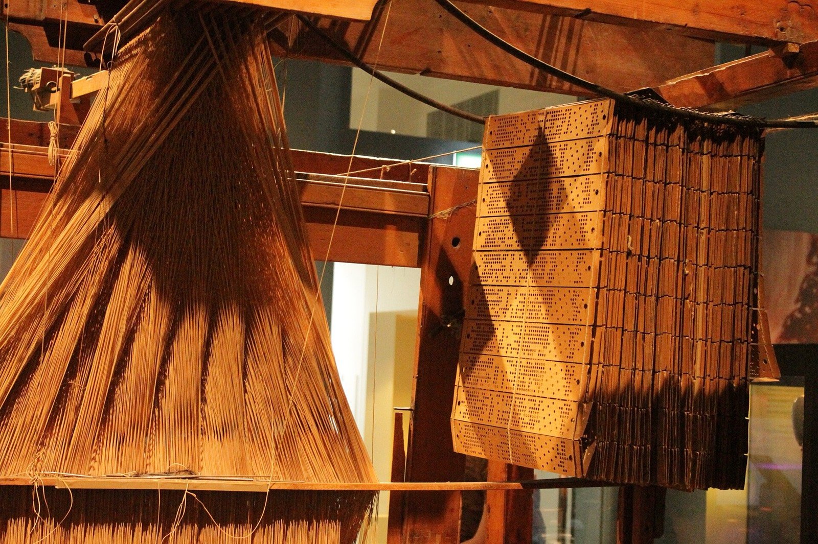 Tear de Jacquard com os cartões perfurados pendurados ao lado, em um museu